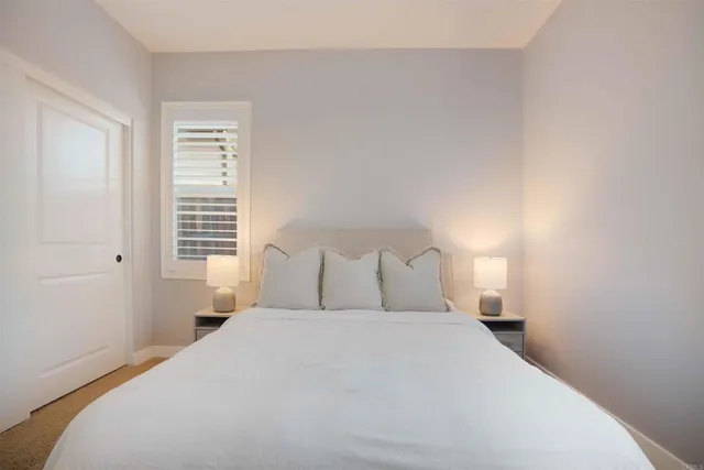 a bedroom with a bed and a painting on the wall