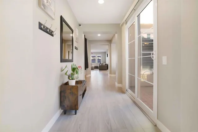 a view of a hallway to a livingroom with furniture and wooden floor