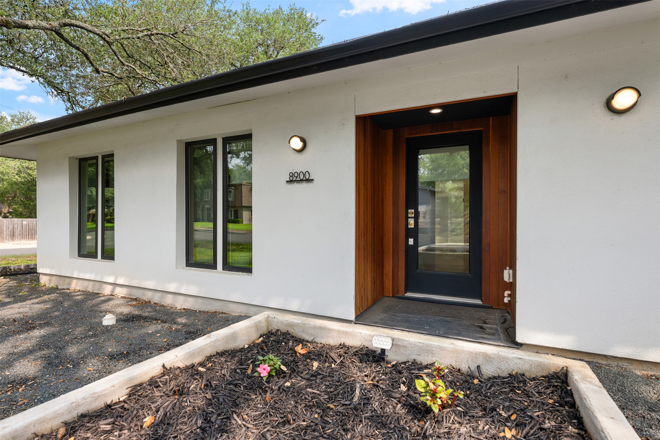 8900 Point W Drive Austin, TX 78759 - Photo 2 of 40 Modern facade with sleek black-framed windows and a warm wood-accented entry.