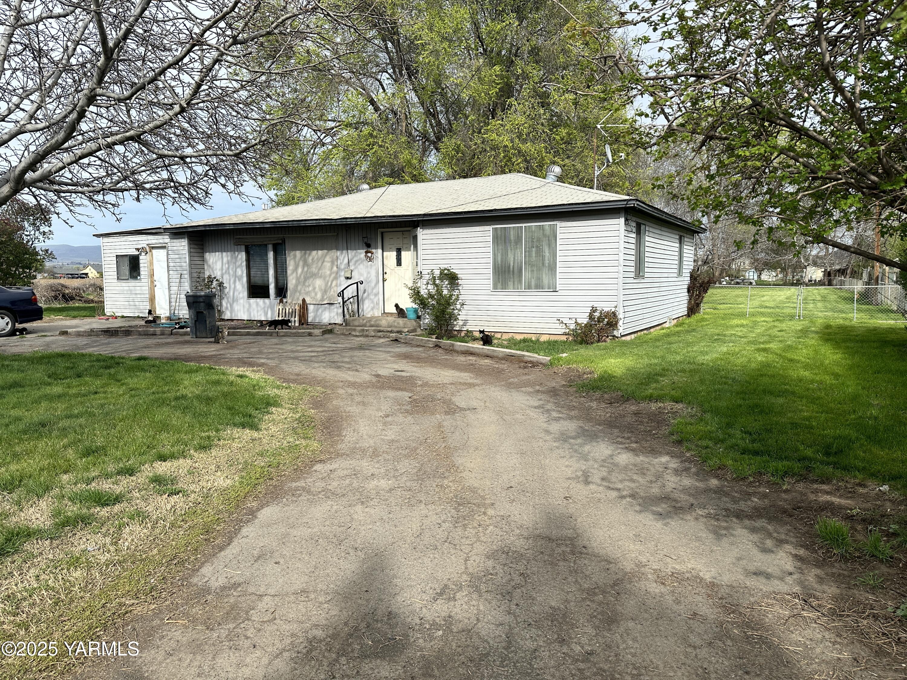 1122 McClain Drive Sunnyside, WA 98944 - Photo 1 of 8 a front view of a house with a garden and trees