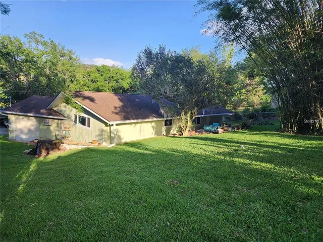 a aerial view of a house with a big yard and large trees