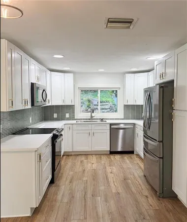 a kitchen with stainless steel appliances a refrigerator sink and microwave