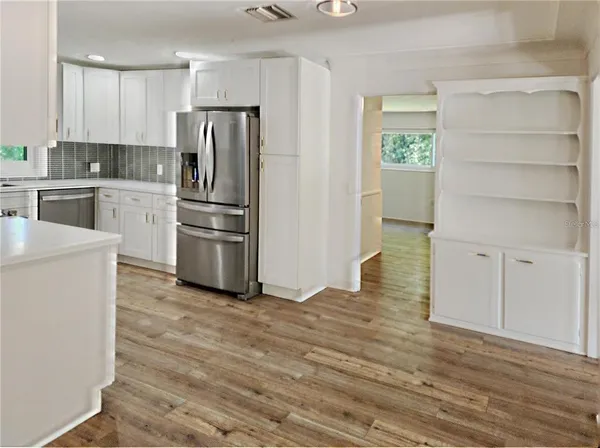 a kitchen with a refrigerator stove and white cabinets