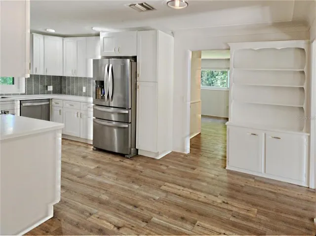 a kitchen with a refrigerator stove and white cabinets
