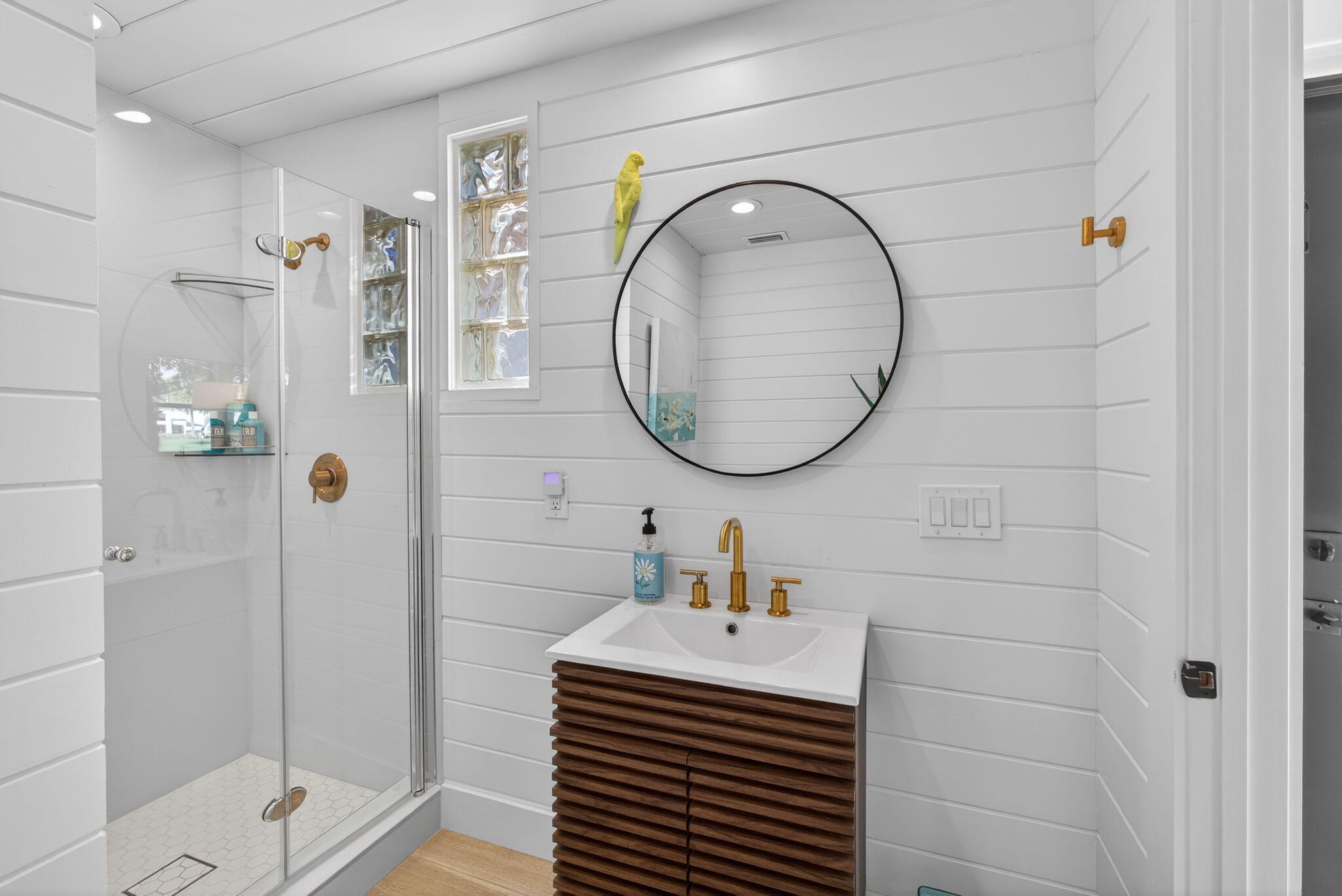 17085 Bay Street Jupiter, FL 33477 - Photo 30 of 44 a bathroom with a sink a glass door shower and a mirror