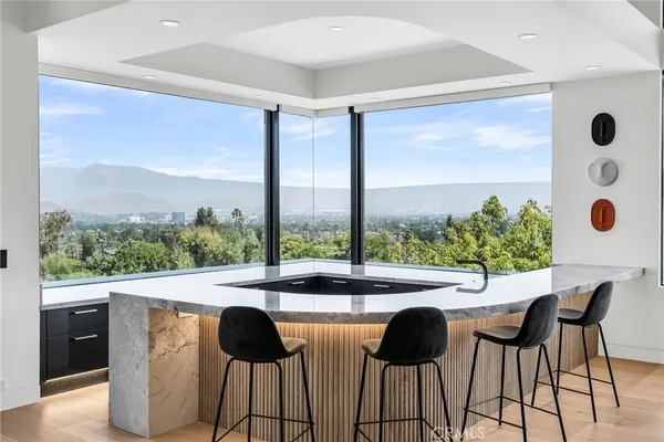 a large kitchen with kitchen island a large counter top stainless steel appliances and cabinets