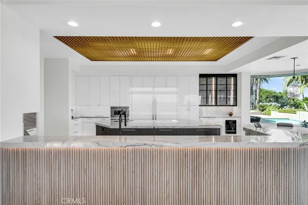 a large white kitchen with a large window and stainless steel appliances