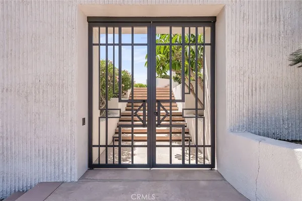 a view of a house with potted plants in front of door