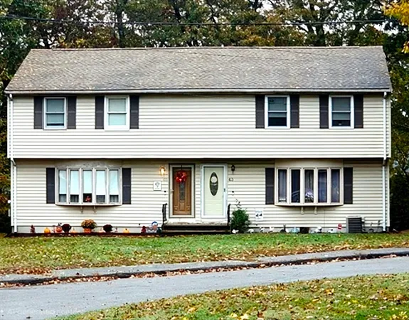 a front view of a house with a garden and plants