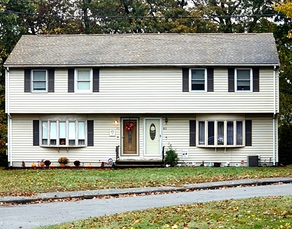 a front view of a house with a garden and plants