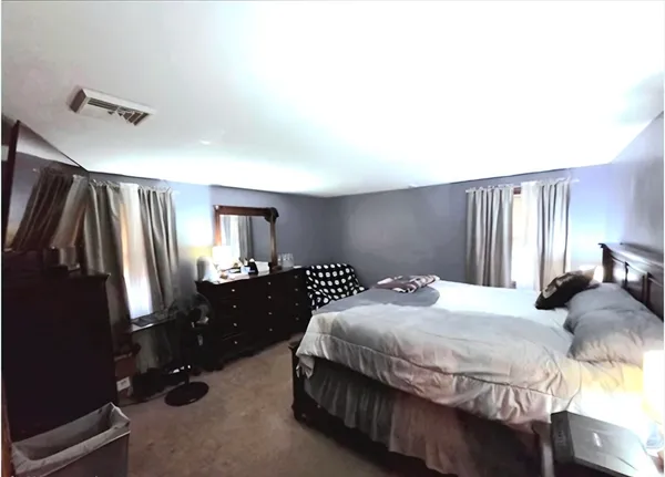 a bedroom with a bed and a large mirror on dresser