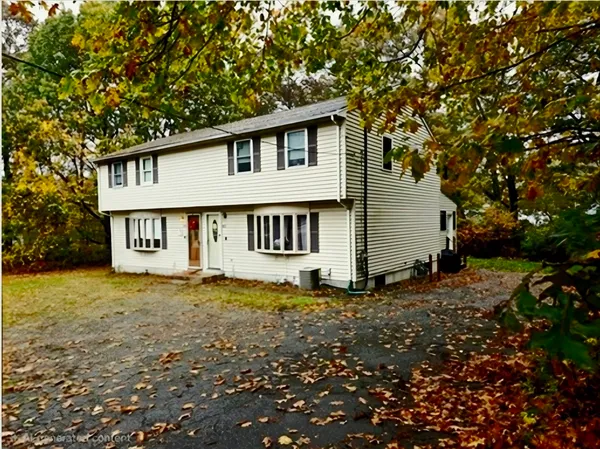 a view of a house with a large tree and a yard
