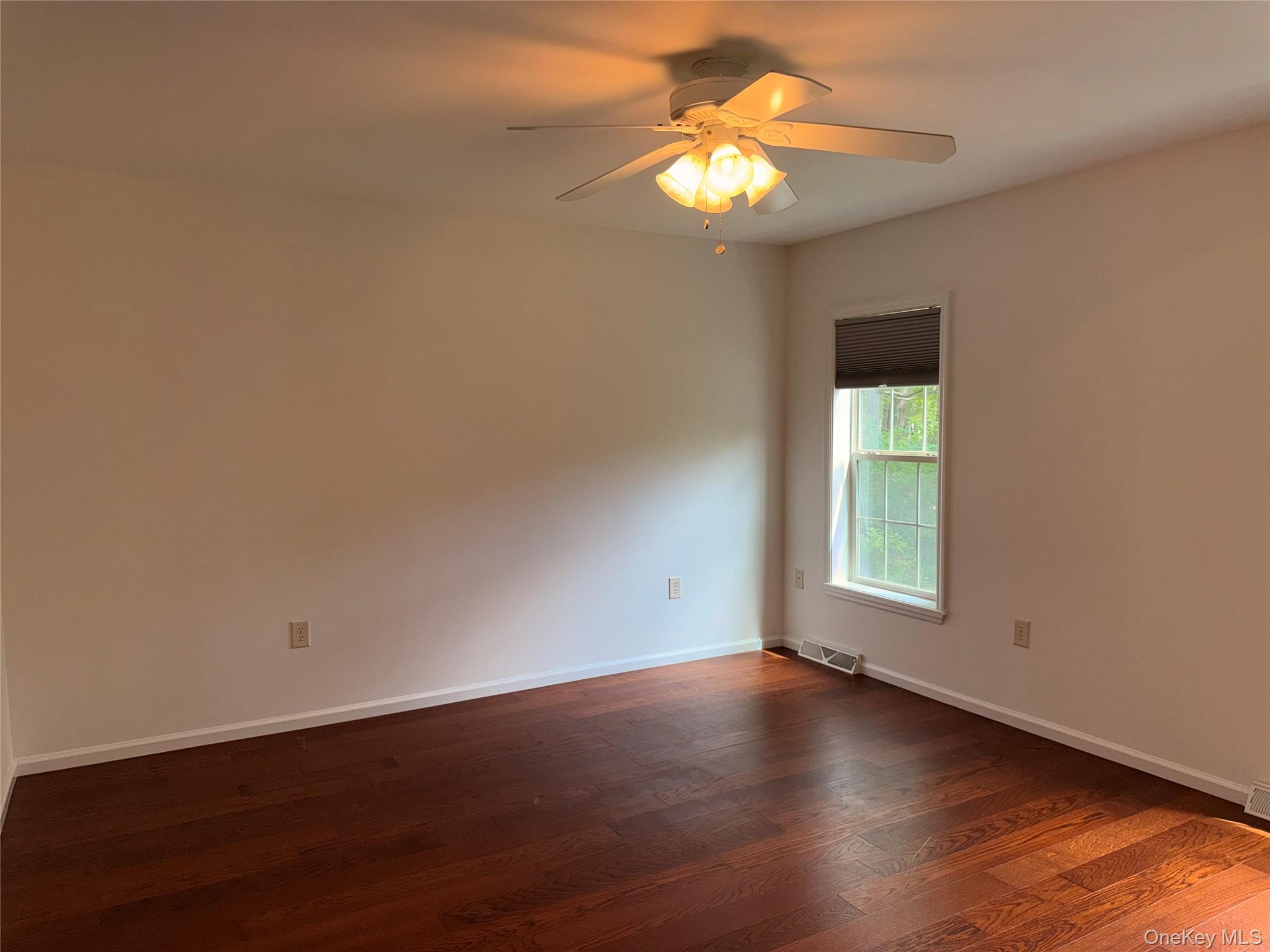 1661 Old Country Road, Unit 516 Riverhead, NY 11901 - Photo 35 of 50 an empty room with wooden floor and windows