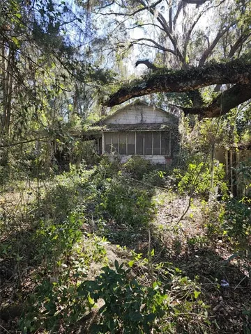 a big house with large trees and plants