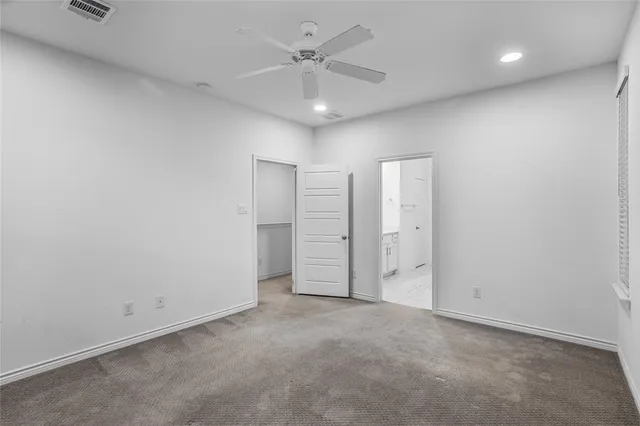 an empty room with closet and a ceiling fan