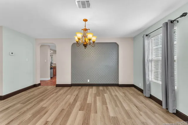 a view of a livingroom with wooden floor and a chandelier