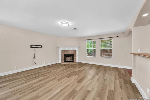 wooden floor fireplace and natural light in room