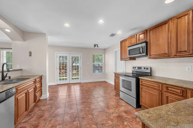 a kitchen with stainless steel appliances granite countertop a stove a sink and a microwave