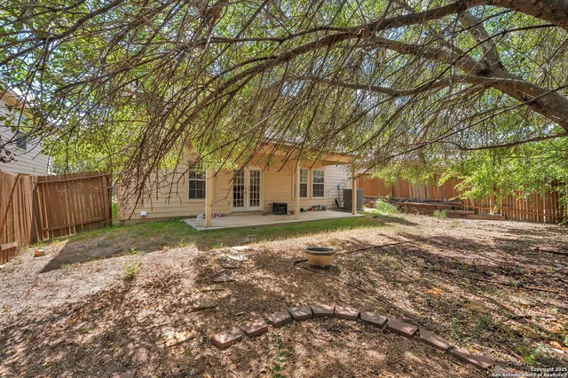 a view of a house with a big yard and large trees