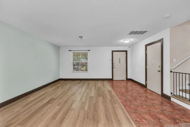a view of an empty room with wooden floor