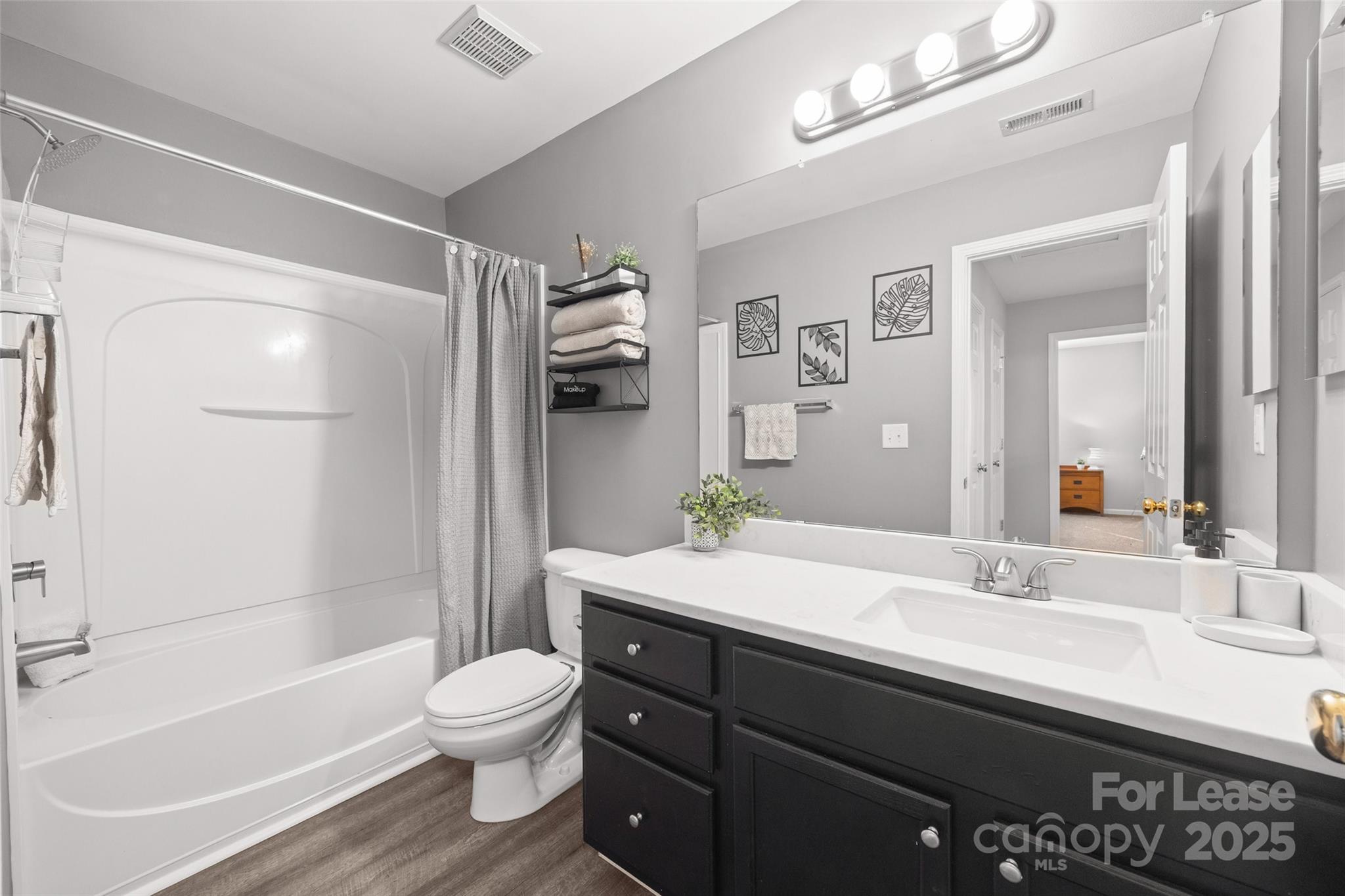 16865 Timber Crossing Road Charlotte, NC 28213 - Photo 23 of 39 a bathroom with a granite countertop sink toilet a large mirror a bathtub and shower