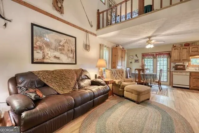 a kitchen with stainless steel appliances granite countertop a refrigerator a stove a sink and white cabinets with wooden floor