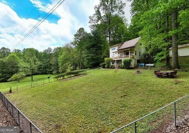 an aerial view of house with yard and trees in the background