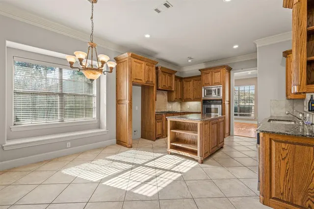 a kitchen with stainless steel appliances granite countertop a stove a sink a refrigerator and cabinets