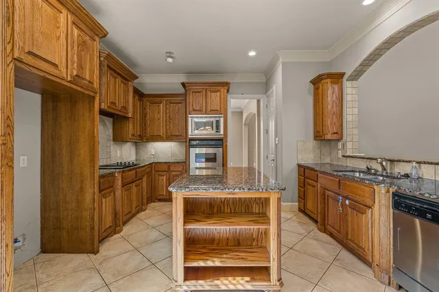 a kitchen with stainless steel appliances granite countertop a refrigerator and a stove top oven