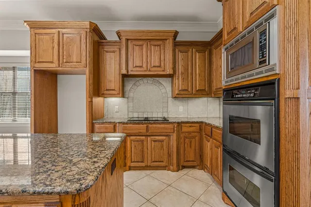 a kitchen with granite countertop cabinets stainless steel appliances and a counter space