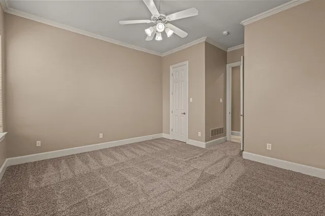 an empty room with closet and a chandelier fan