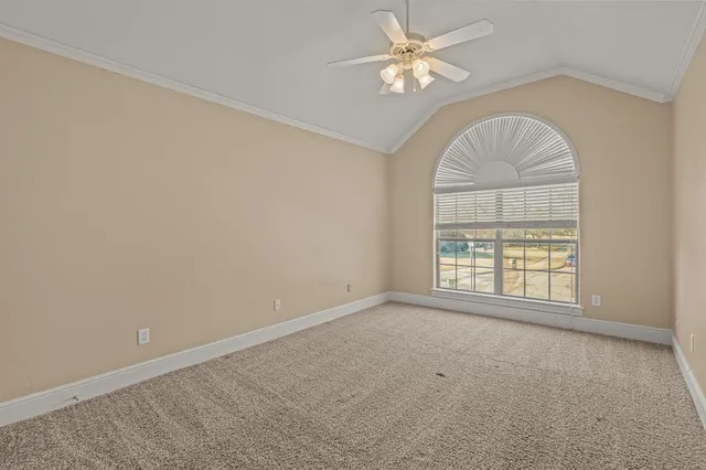 an empty room with a ceiling fan and window
