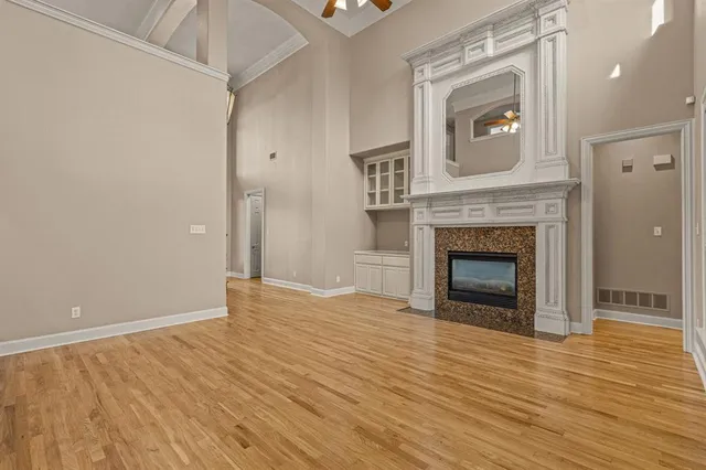 a view of empty room with wooden floor and fireplace