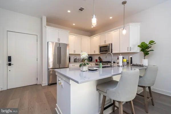 a kitchen with refrigerator cabinets and wooden floor