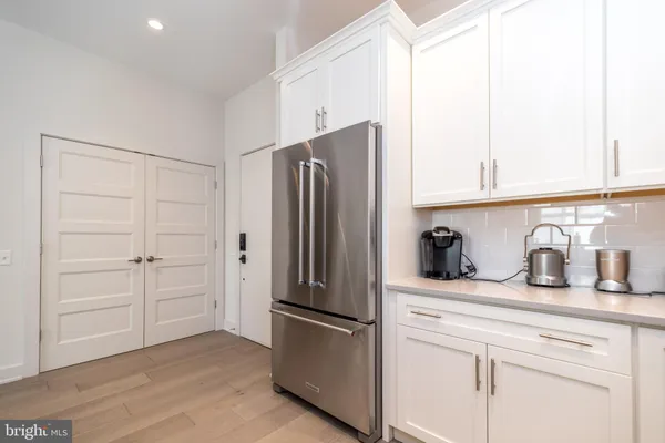 a kitchen with white cabinets and white appliances
