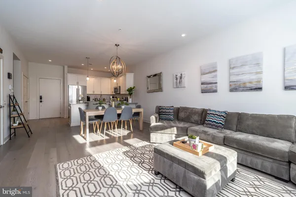 a living room with furniture and a dining table with wooden floor