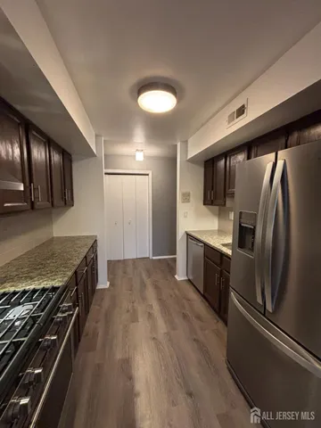 a kitchen with stainless steel appliances granite countertop a refrigerator and a stove top oven