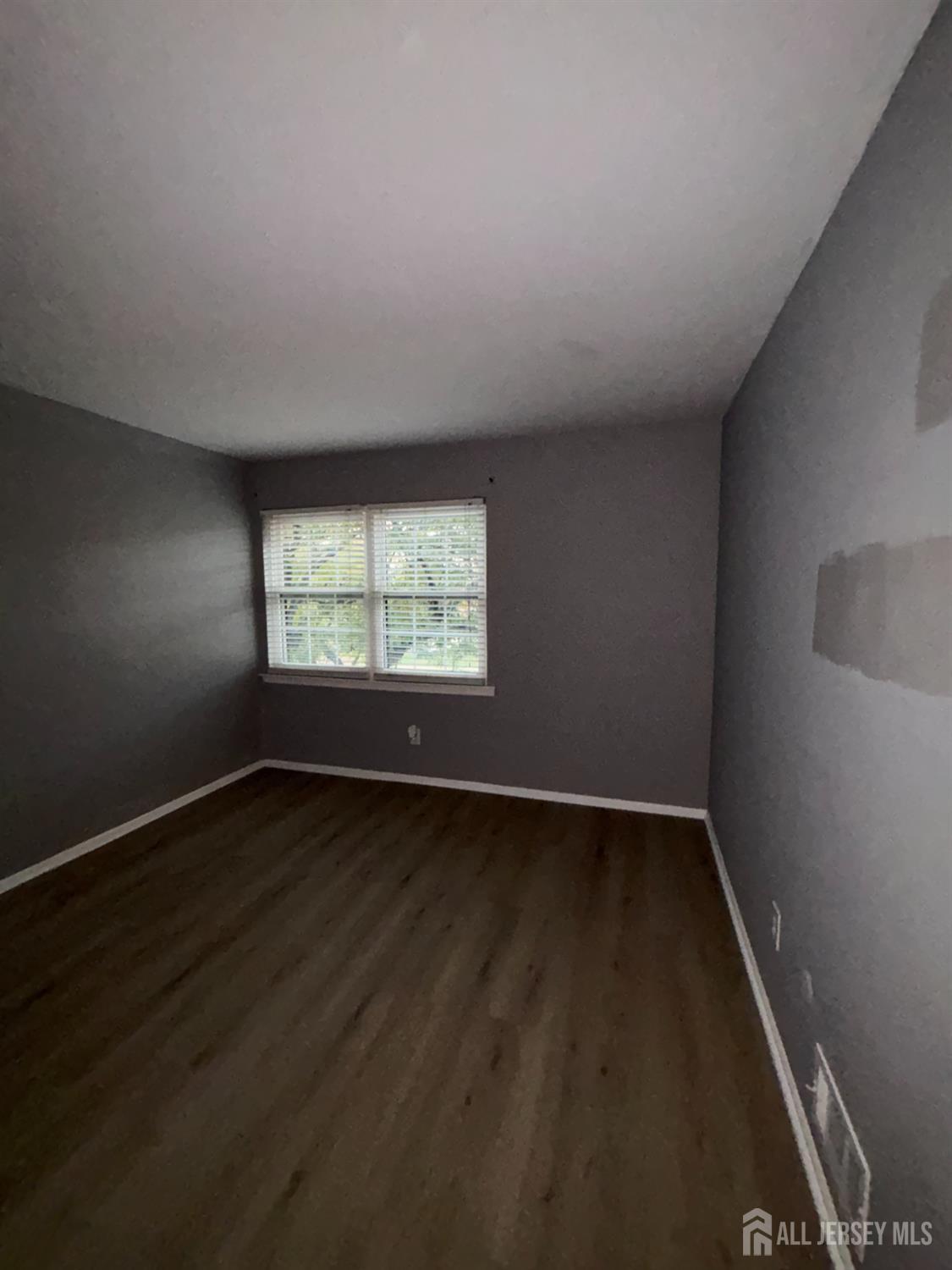 42 B Powderhorn Court, Unit 42B Woodbridge, NJ 07095 - Photo 11 of 14 an empty room with wooden floor and windows