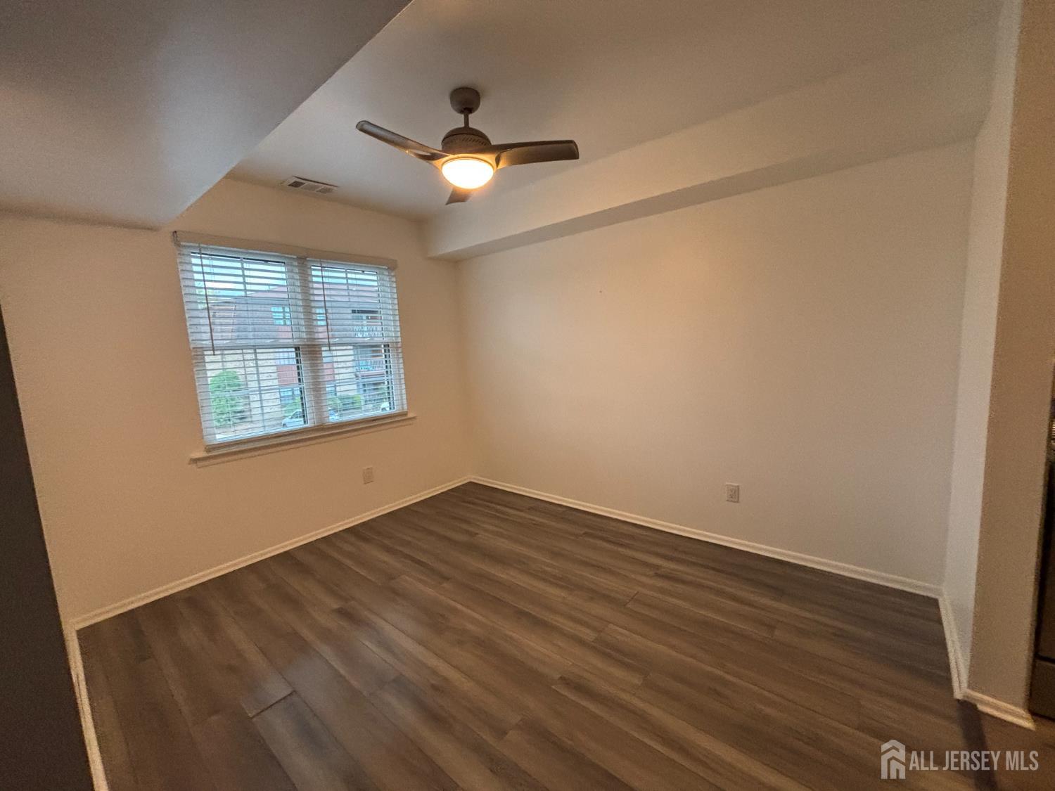 42 B Powderhorn Court, Unit 42B Woodbridge, NJ 07095 - Photo 4 of 14 an empty room with wooden floor and windows