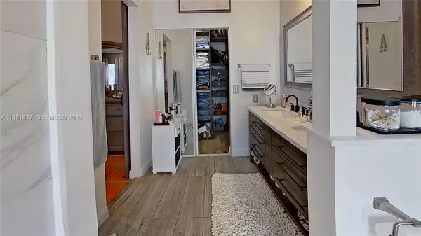 a kitchen with stainless steel appliances granite countertop a refrigerator and a wooden floor