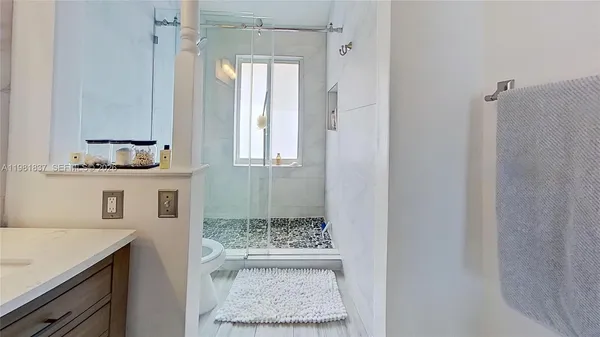 a bathroom with a granite countertop sink a mirror and a shower