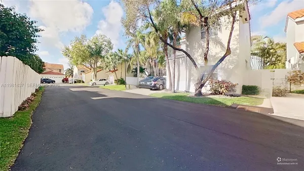 a view of a house with a big yard and palm trees