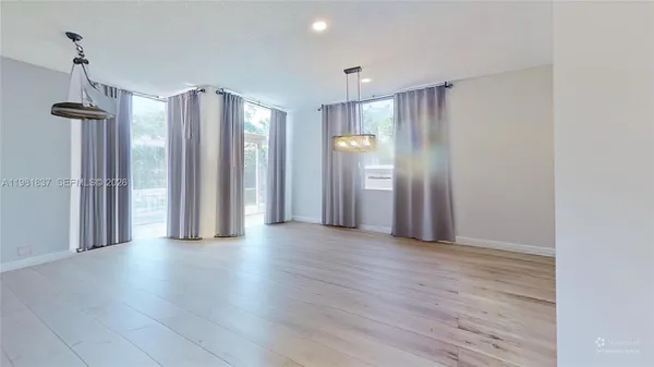 a view of a room with wooden floor