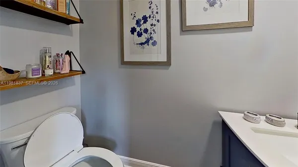 a white toilet sitting next to a bathroom sink