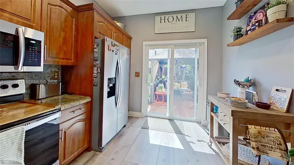 a kitchen with stainless steel appliances granite countertop a refrigerator a stove top oven a sink and dishwasher
