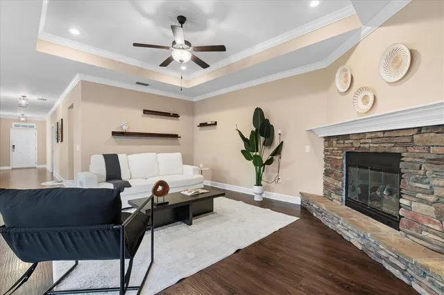 a living room with furniture a fireplace and a ceiling fan
