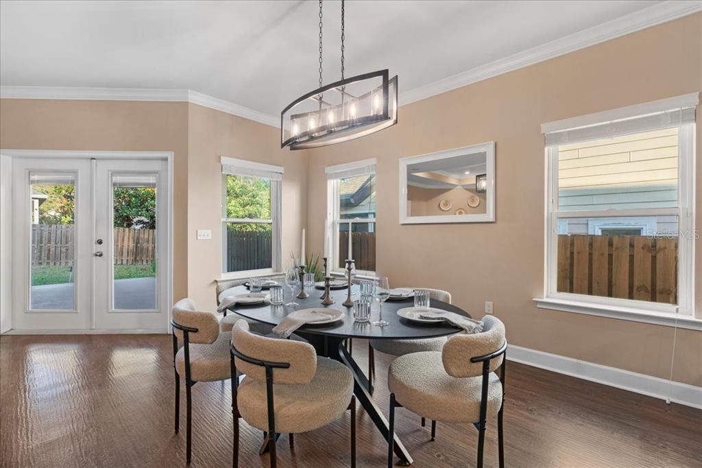 9834 Northwest 17th Road Gainesville, FL 32606 - Photo 13 of 51 a view of a dining room with furniture large windows and wooden floor