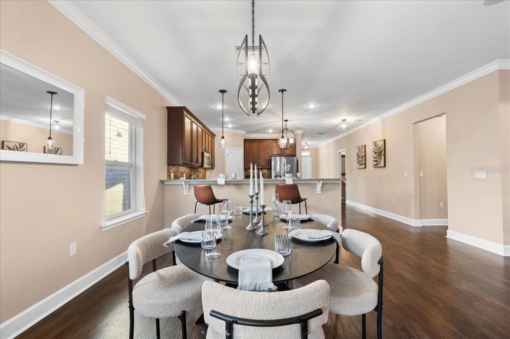 9834 Northwest 17th Road Gainesville, FL 32606 - Photo 14 of 51 a view of a dining room with furniture wooden floor and chandelier