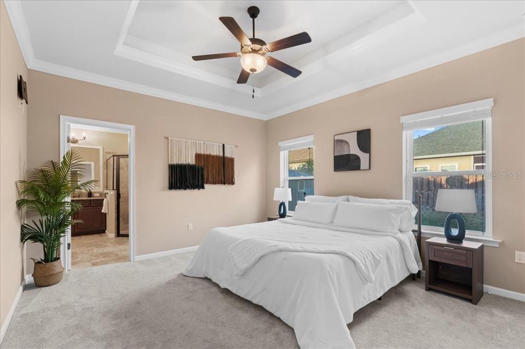 9834 Northwest 17th Road Gainesville, FL 32606 - Photo 15 of 51 a bedroom with a large bed a chandelier and a couch