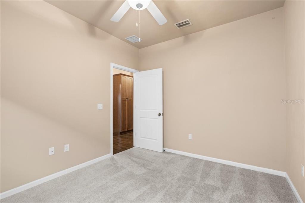 9834 Northwest 17th Road Gainesville, FL 32606 - Photo 27 of 51 an empty room with a ceiling fan and painted walls